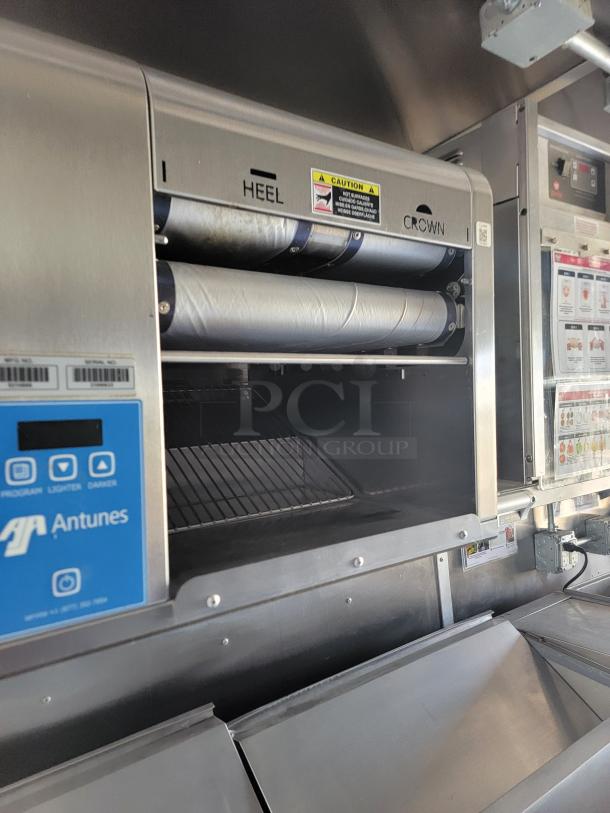 Commercial sandwich toaster by Antunes in stainless steel. Features "Heel" and "Crown" labeling with caution signage. Good condition.