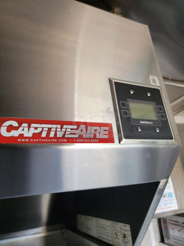 CaptiveAire stainless steel kitchen hood with digital control panel. Features brand logo and contact details.