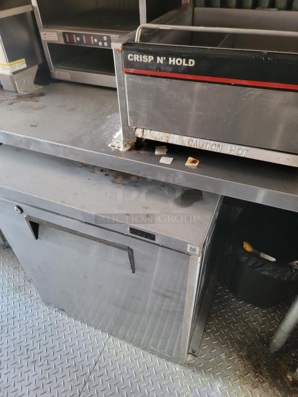 Commercial Crisp N' Hold food warmer in used condition, showing signs of rust, with caution hot labeling and stainless steel finish.