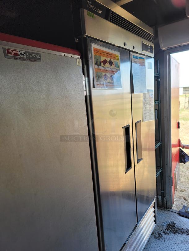 Turbo Air commercial refrigerator and Metro C5 Series heated cabinet. Both in stainless steel. Information sheets visible.