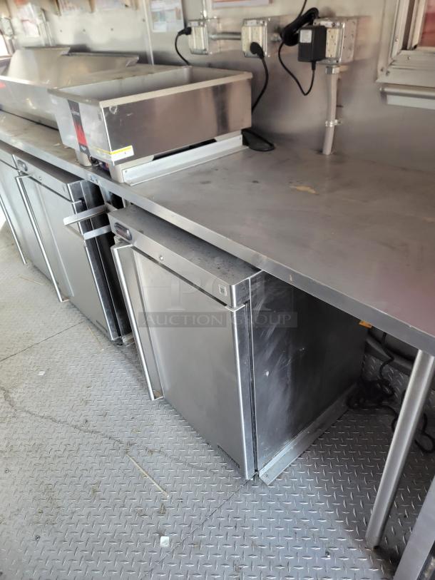 Stainless steel commercial kitchen setup with countertop, under-counter fridge, and warming drawer, in good condition.