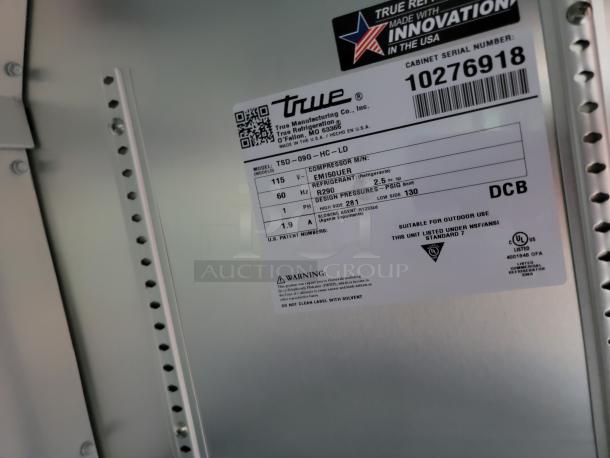 Close-up of a label on a True refrigerator, model TSD-09G-HC-LD, indicating compressor and refrigerant details.