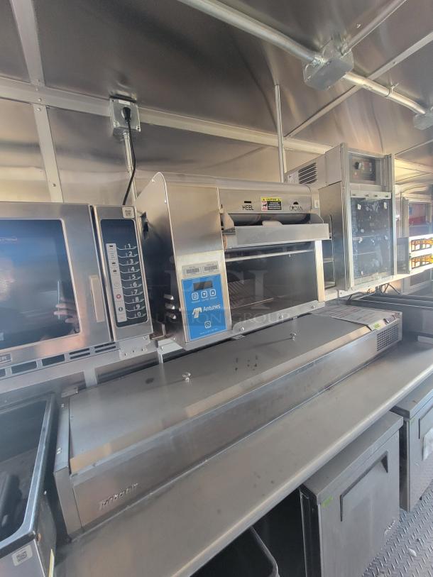 Commercial kitchen equipment featuring Antunes toaster with digital controls, stainless steel finish, and "HEEL" and "CROWN" labeled slots.