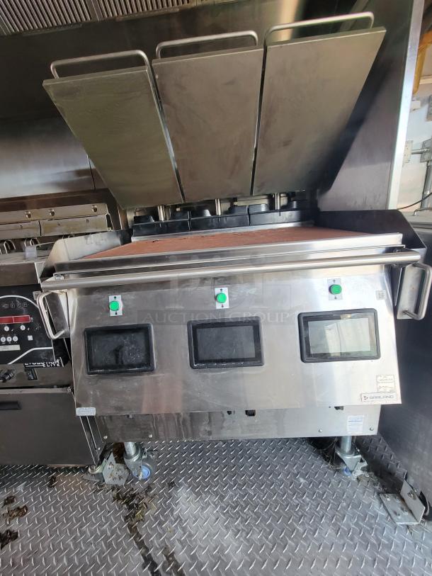 Stainless steel commercial grill with digital controls, three levers, and visible Garland branding, in used condition.