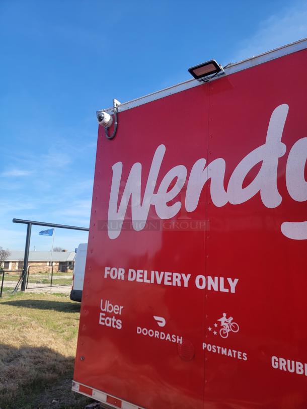 Red delivery-only food truck featuring delivery service logos: Uber Eats, DoorDash, Postmates, Grubhub. Security camera installed.