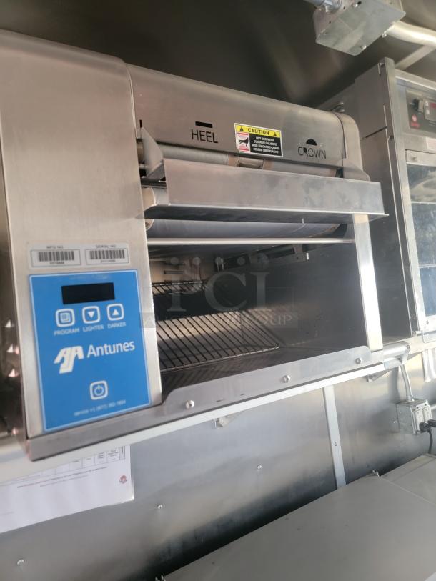 Antunes commercial toaster, stainless steel, featuring "HEEL" and "CROWN" labels, caution sticker, and control panel.