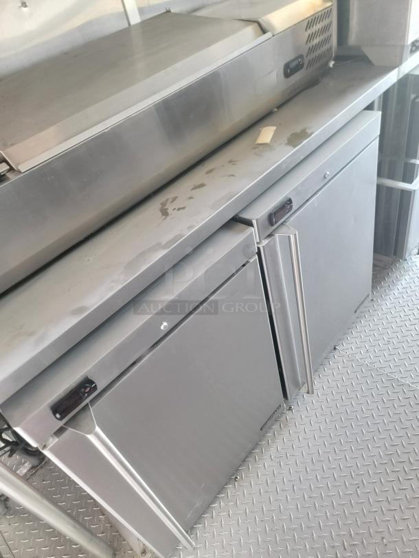 Commercial stainless steel refrigeration unit with two doors. Features digital control panel. Appears in used condition.