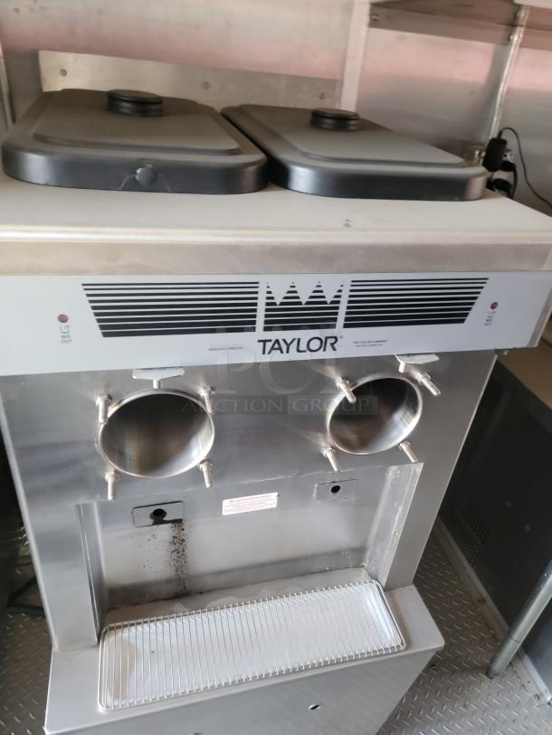 Taylor ice cream machine, dual dispenser, stainless steel, used condition, visible branding, model info obscured.
