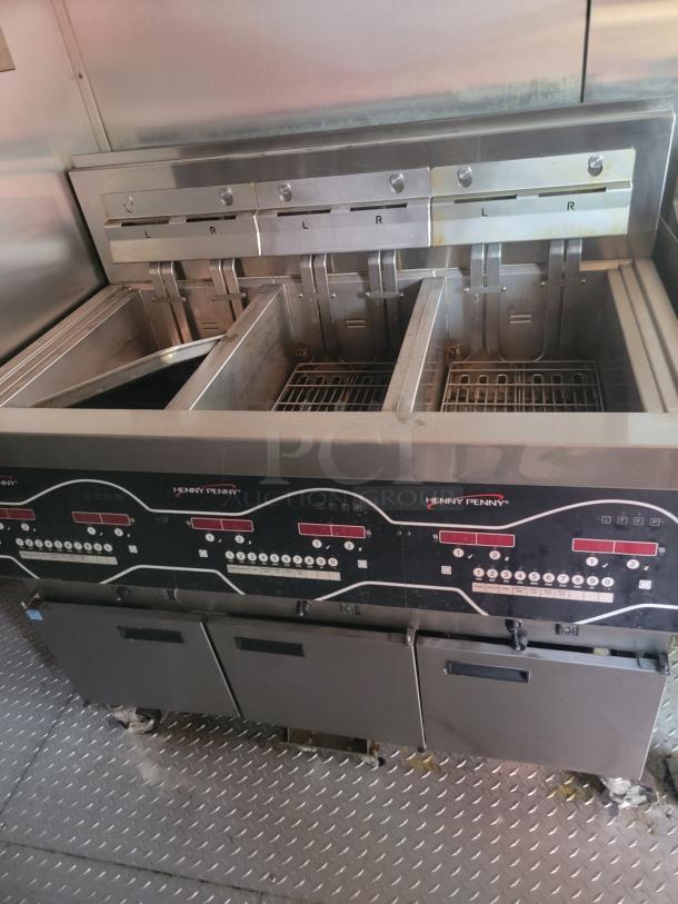 Henny Penny commercial deep fryer with dual baskets, stainless steel, digital controls. In used condition, visible wear.