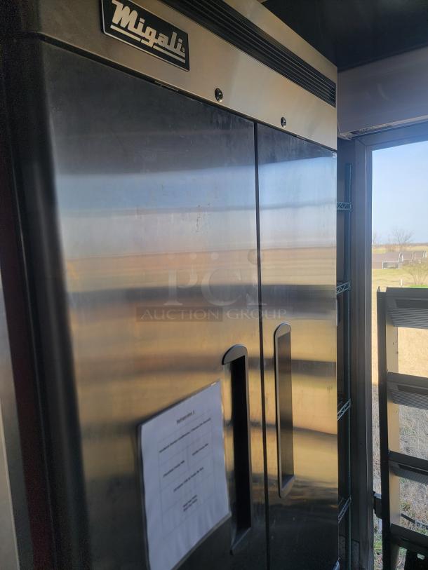 Migali stainless steel commercial refrigerator. Dual doors, visible labeling, excellent condition, industrial-grade quality.