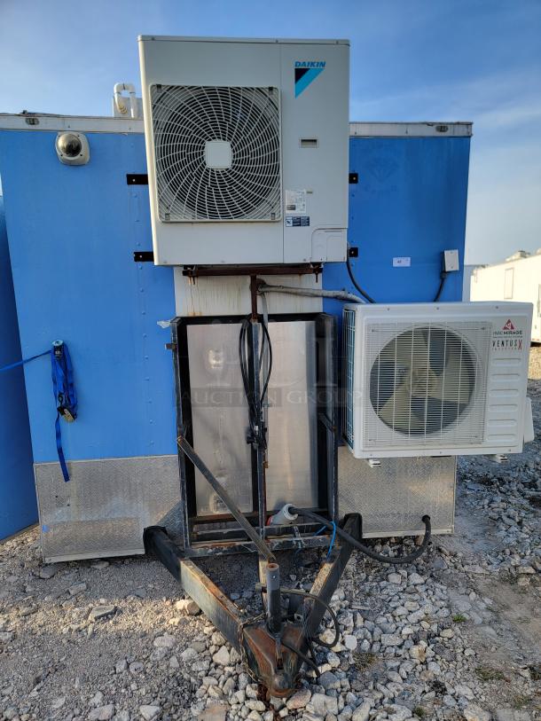 Dual air conditioning units, featuring Daikin and VMAC Mirage VentusX models, on a blue trailer. Signs of rust on the trailer hitch.