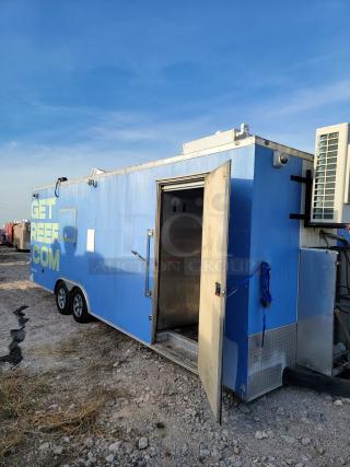 Blue mobile kitchen trailer with dual axles and "GET REEF COM" markings. Open side door, exterior refrigeration unit, good condition.