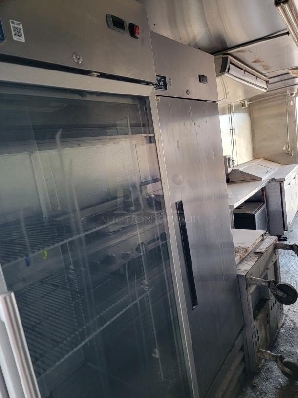 Stainless steel commercial refrigerator by Arctic Air. Features glass door, adjustable shelves, some wear.
