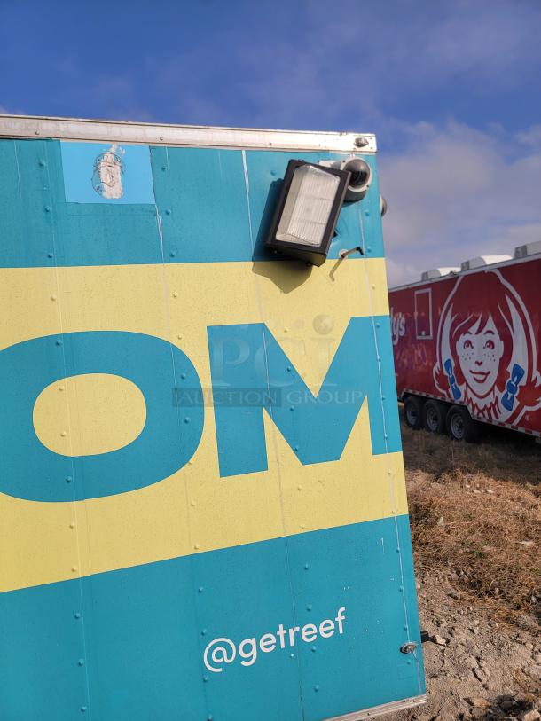 Colorful mobile food truck with "@getreef" branding and mounted light. Partial view of another truck in the background.