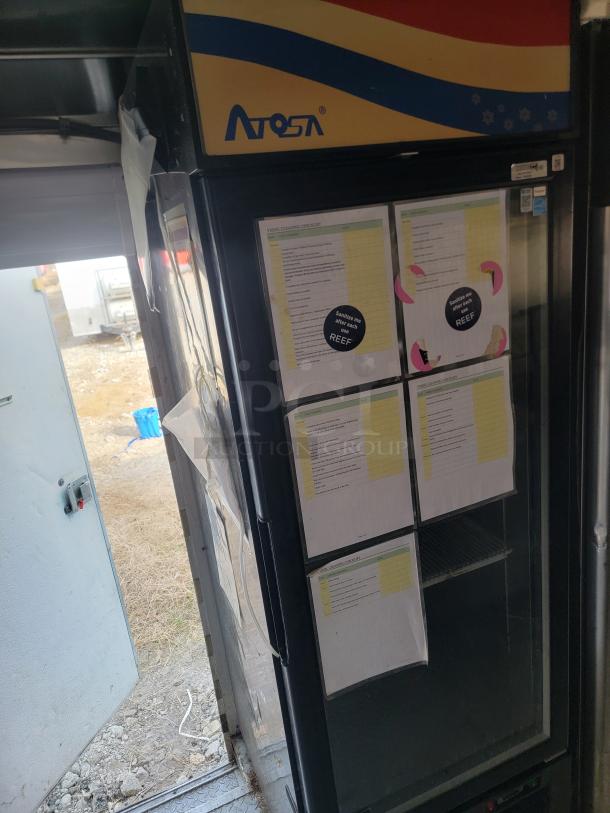 Atosa commercial refrigerator with glass door, featuring cleaning checklists and "Sanitize me after use" stickers. Used condition.
