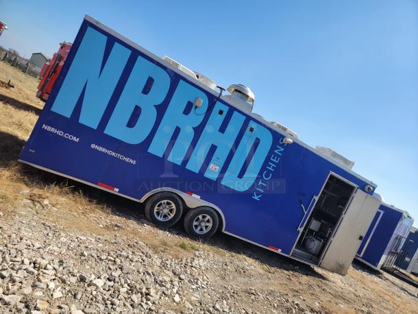 Blue NBRHD Kitchens food trailer with dual axles. Features ventilation system. Visible branding includes “NBRHD” and website.