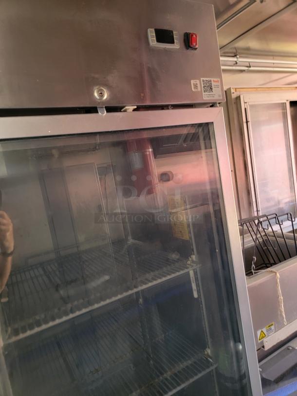 Commercial refrigerator with glass door, featuring wire shelves. Upper panel shows digital display and red switch. Good condition.