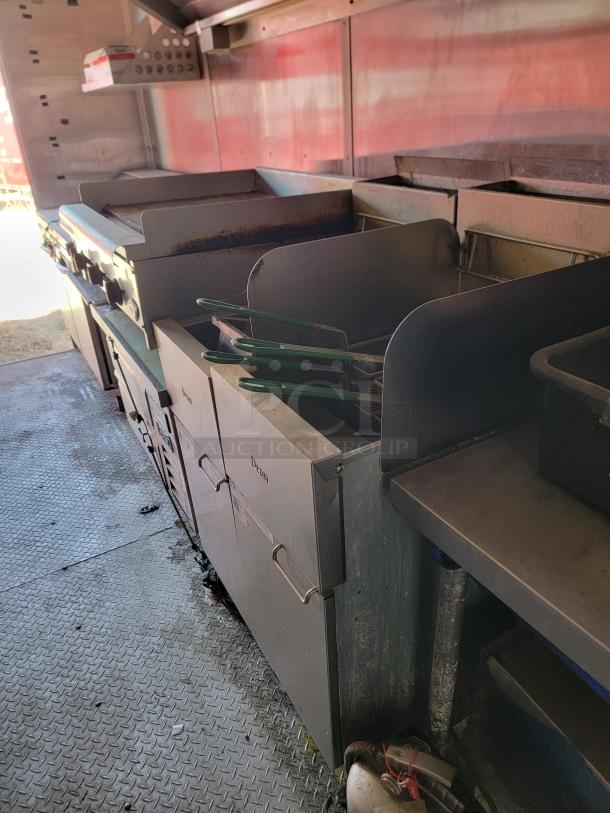 Commercial kitchen equipment including two deep fryers and a flat-top grill. Used condition with visible wear. Brand: Dean.
