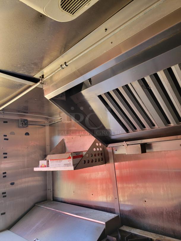 Commercial kitchen ventilation hood, stainless steel, includes shelving and storage. Good condition, Sysco plastic food wrap visible.