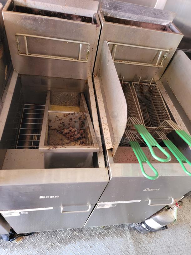 Two Dean commercial fryers, used condition, with dual baskets and green handles. Noticeable wear and residue present.