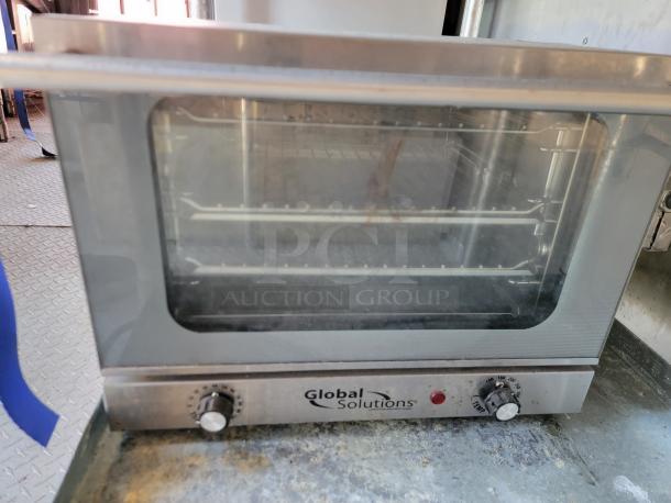 Global Solutions countertop oven, stainless steel, dual knobs, clear glass door, visible racks, used condition.
