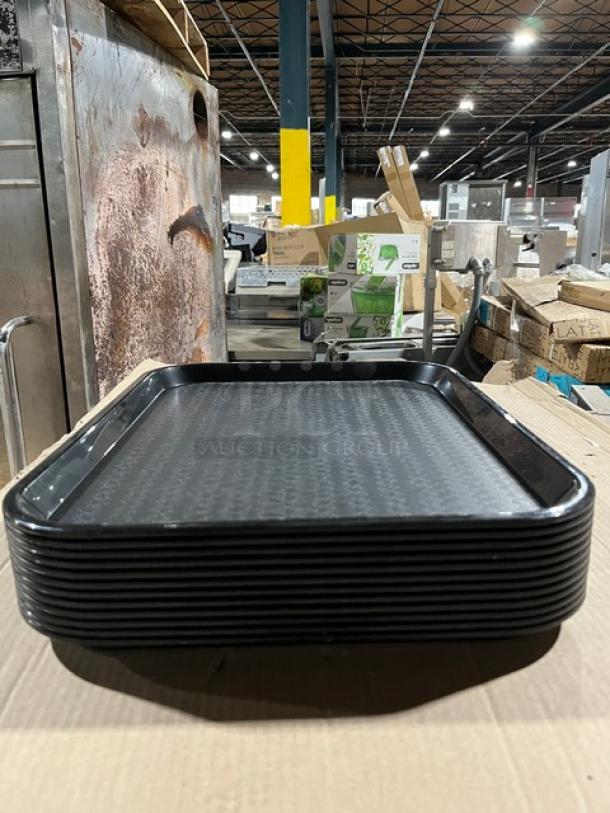 Carlisle Commercial black serving trays, model CT141803, each 14"x18", brand new condition, showing a stack in warehouse.