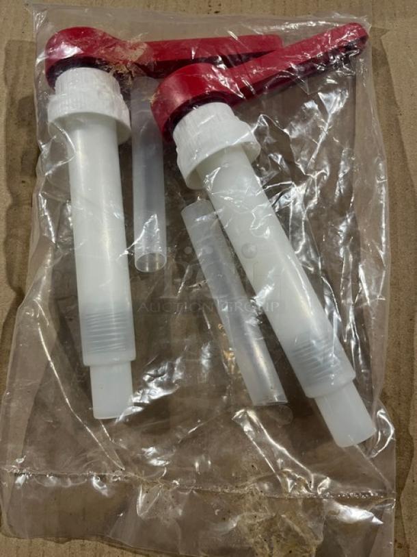 Brand new commercial condiment dispenser pump with red top, sealed in plastic packaging, includes two pumps and parts.