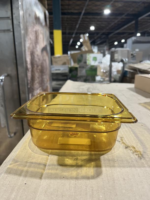 Brand new Rubbermaid Commercial Amber High Heat 1/6 Size Food Pan, Model FG204P00AMBR, showcased on a wooden surface.