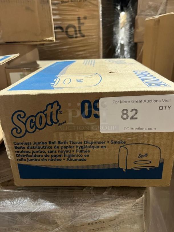 Brand new Scott model 09602 jumbo roll bath tissue dispenser, smoke color, in box. Box label shows PCI Auctions info and quantity 82.