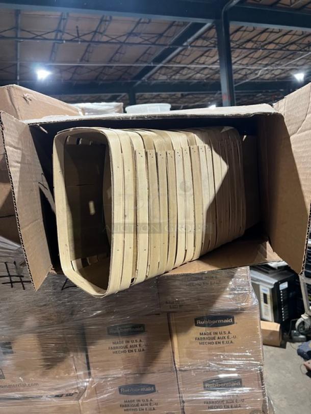 Cardboard box containing commercial oval plates and Rubbermaid Brute Series lids. Stacked on pallets in warehouse.