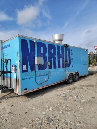 Large blue food trailer with "NBRHD KITCHENS" branding, multiple hatches, exhaust vent on top, and visible wear.