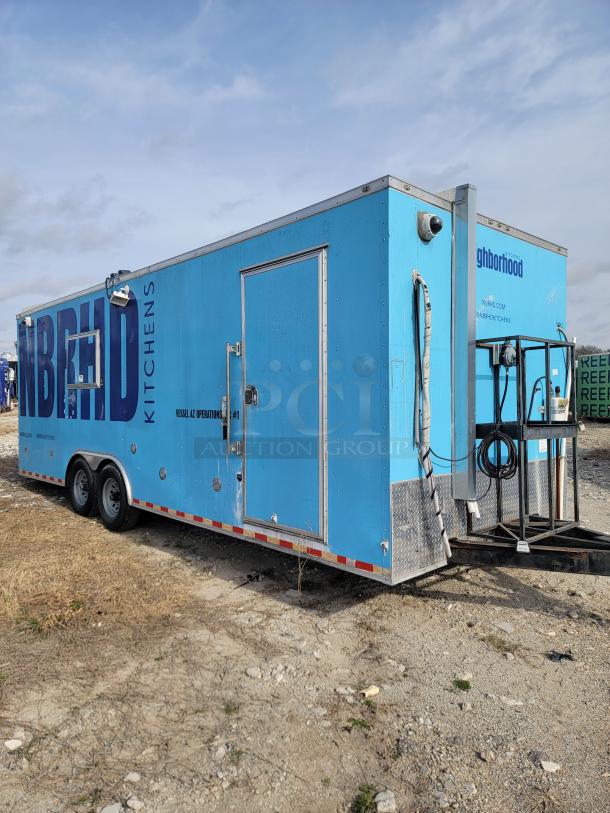 Blue mobile kitchen trailer with "Neighborhood Kitchens" branding. Dual axle, metal exterior, and utility hookups visible. Good condition.