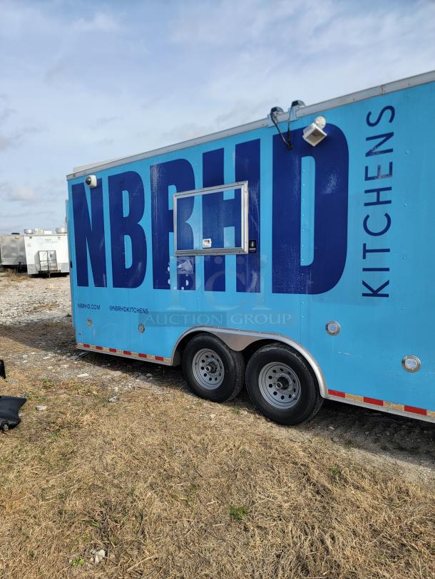 Blue mobile kitchen trailer with "NBRHD KITCHENS" branding. Features service window and dual axles. Used condition.