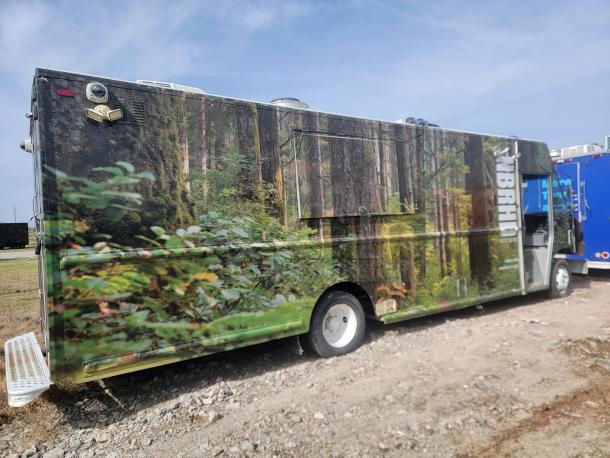 Food truck with forest-themed wrap, featuring prominent "BRHD Kitchens" logo. Good condition, white wheels, side step visible.