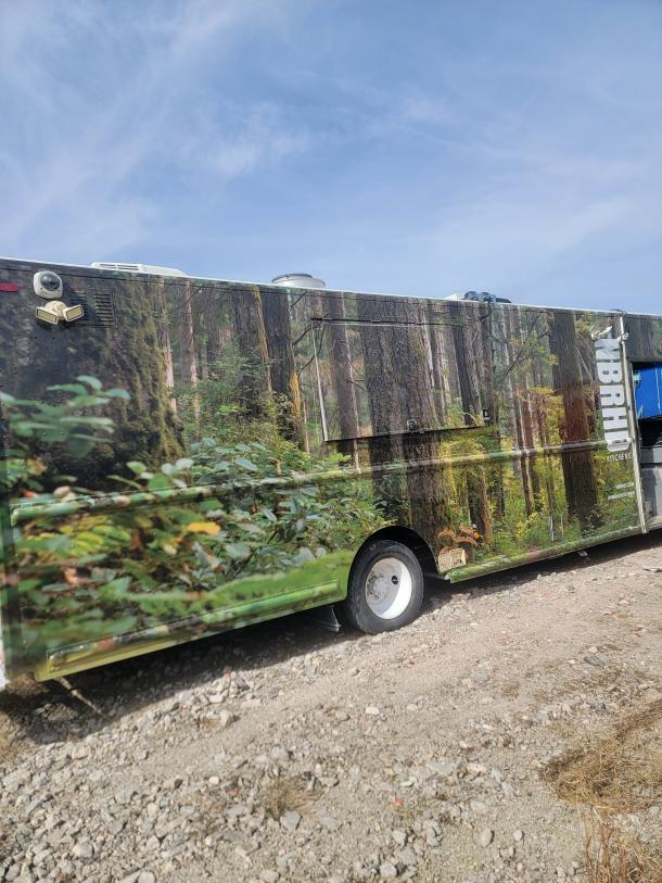 Food truck with forest-themed wrap, equipped with vents and external light. Markings include "KITCHENS". Good exterior condition.