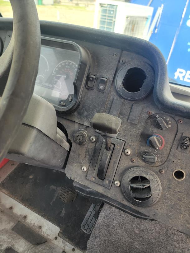 Dashboard of a vehicle showing a dusty condition. Features gear shift, speedometer, air vents, and control knobs.