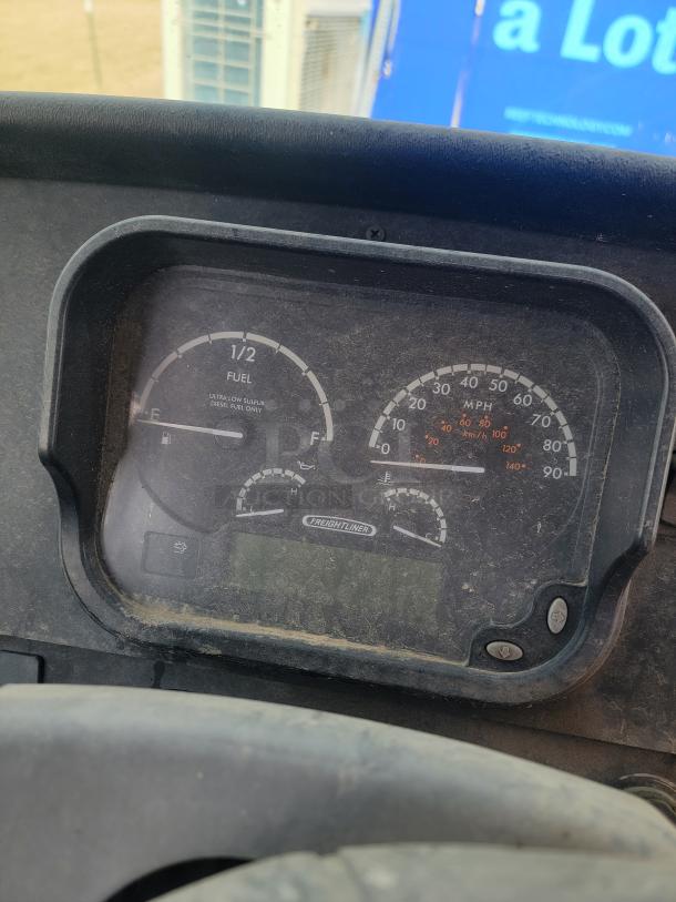 Freightliner dashboard with speedometer, fuel gauge, and odometer, in used condition, showing some dirt.