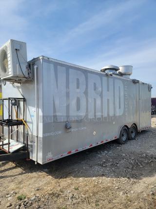 Mobile food trailer with "NBRHD Kitchens" branding, metal exterior, rooftop vent, mounted air unit, dual axles, used condition.