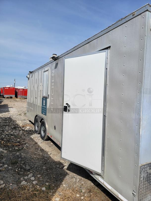 Mobile kitchen trailer with dual axles, branded "BRHD Kitchens." Metal exterior, side door open, used condition.