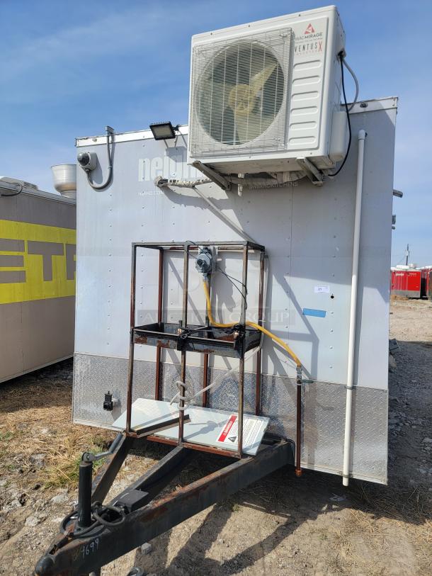 Mobile kitchen trailer with roof-mounted air conditioning unit, diamond plate siding, visible wiring, and external hitch.
