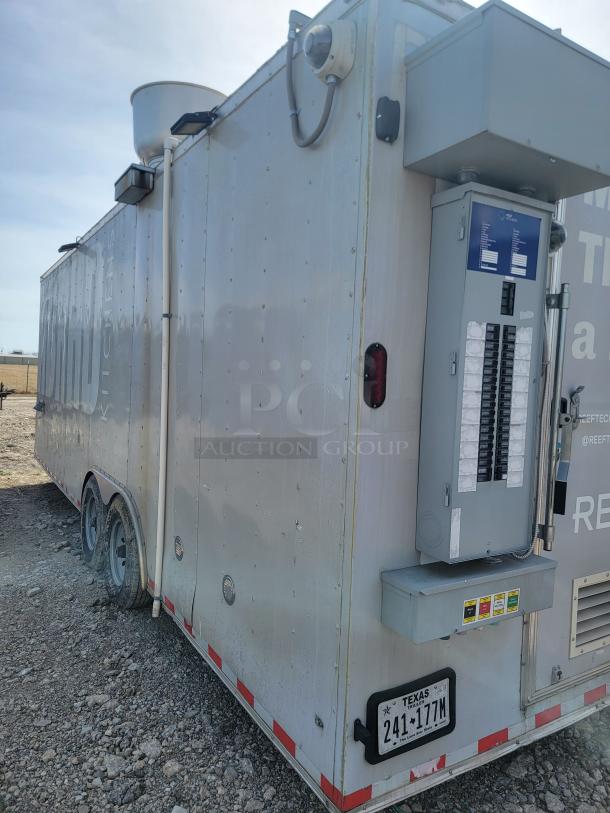 Mobile trailer with electrical panel, dual axle wheels, and Texas license plate. Features a large exhaust vent. Appears used.