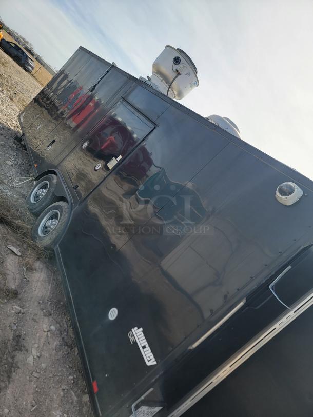 Black Journey SE trailer with dual axles and rooftop vent system, in used condition. Visible branding and model logo on the side.