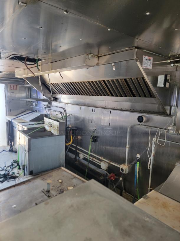 Industrial kitchen exhaust hood in stainless steel, includes venting system. Hoodz service label visible. Good condition.