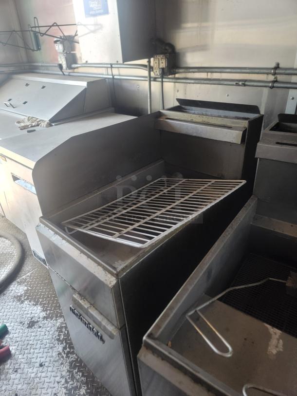 Stainless steel commercial kitchen appliance with grate, showing wear. Features a Hamilton Beach label. Suitable for food prep.