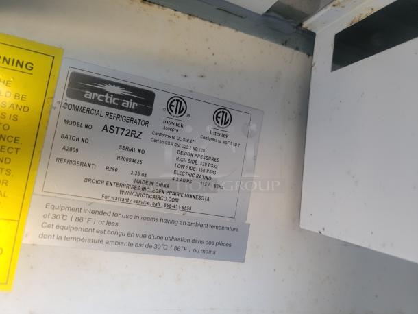 Arctic Air commercial refrigerator, model AST72RZ, label showing specs: Made in China, refrigerant R290, 3.35 oz, 115V.