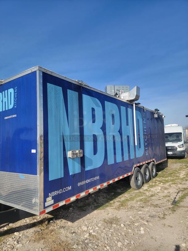 Blue NBRHD Kitchens trailer, three axles, side branding, ventilation equipment on top, visible website and social handles.