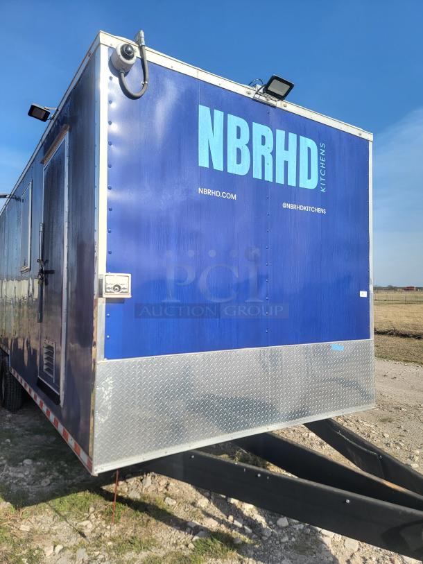 Blue food trailer branded "NBRHD Kitchens" with website and social media handle. Features aluminum siding, metal trim.