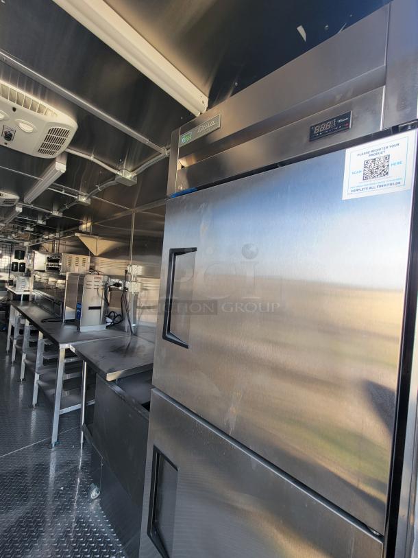 Stainless steel commercial kitchen with True refrigeration unit, digital display, and registration QR code, in excellent condition.