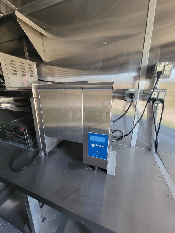 Antunes commercial toaster in stainless steel, mounted on a countertop, with power cables connected. Model and specs not visible.