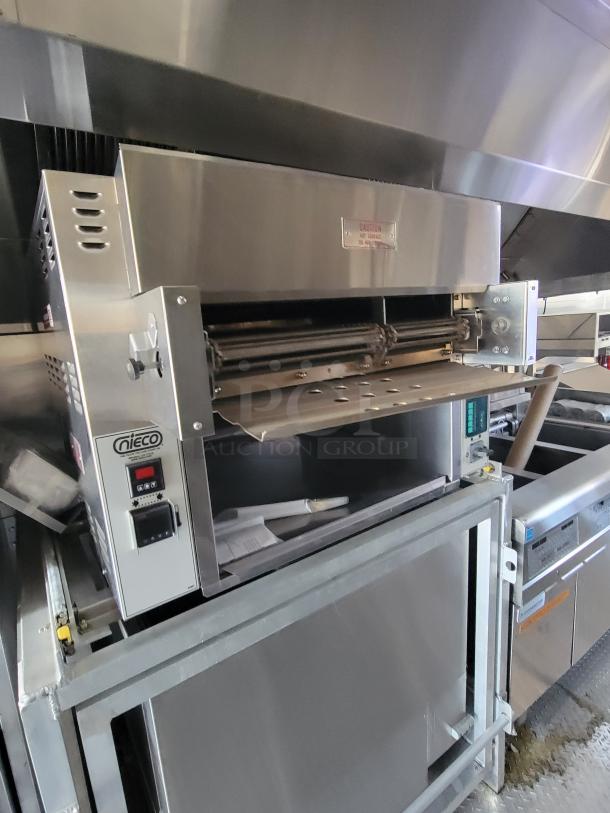 Nieco automatic broiler in stainless steel, model unknown. Features front control panel with buttons. Visible caution label. Good condition.